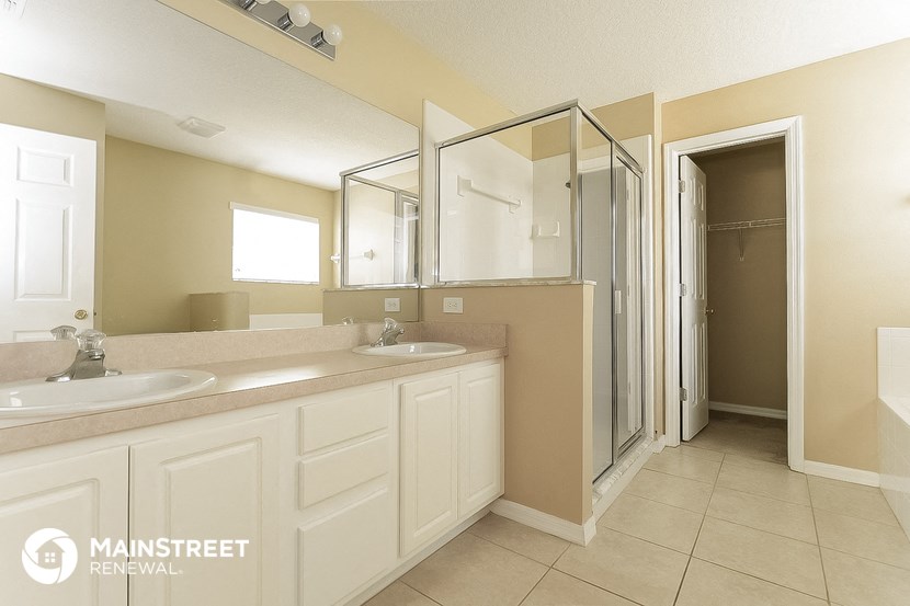 a bathroom with two sinks and a shower and a mirror