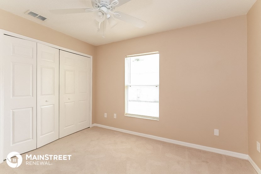 a bedroom with two closets and a ceiling fan