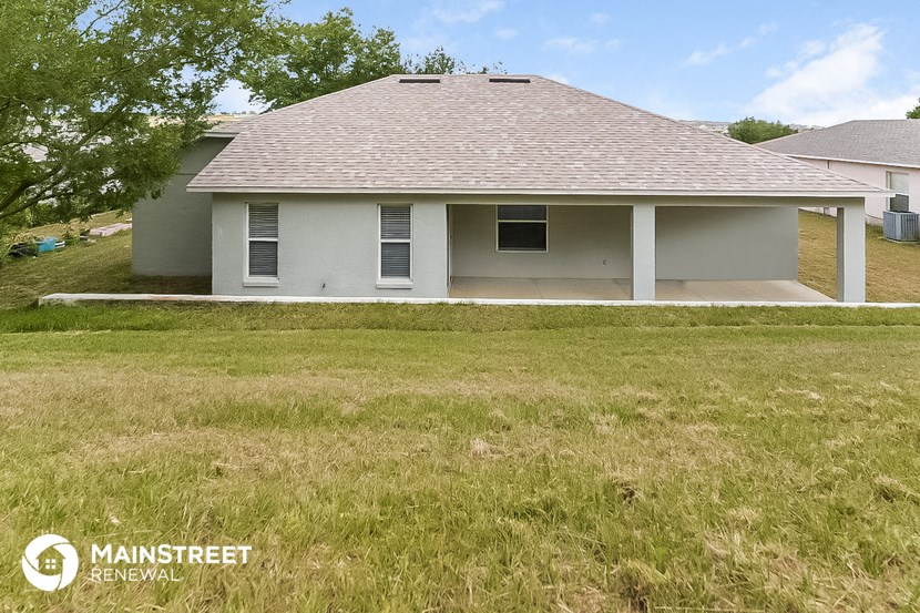 the front of the house with a yard and a garage