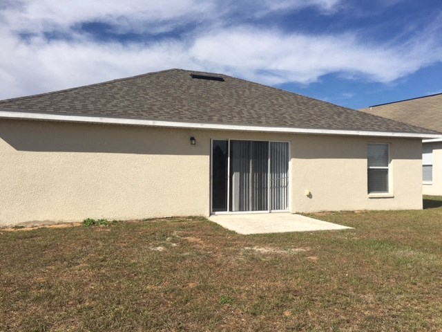 a tan house with a yard and a garage door