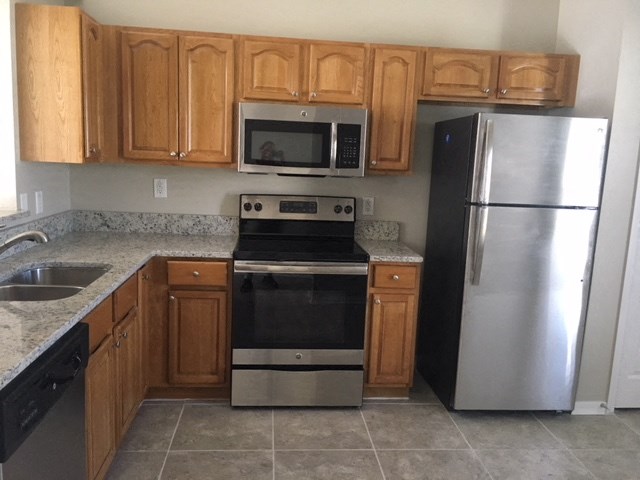 a kitchen with stainless steel appliances and wooden cabinets