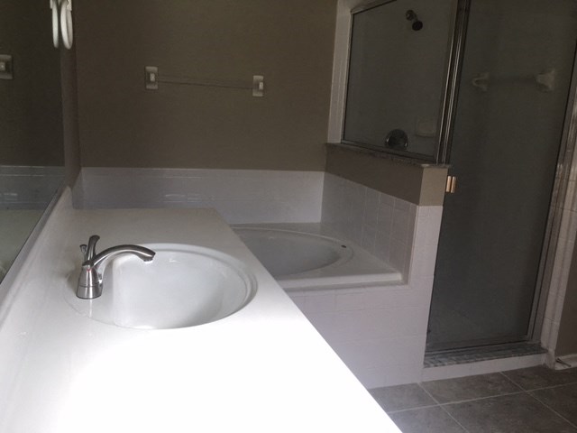 a bathroom with a sink and a tub and a shower
