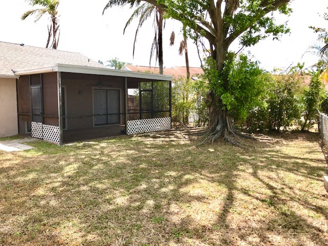 a backyard with a tree and a small house