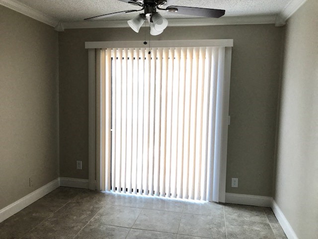 a living room with a window and a ceiling fan