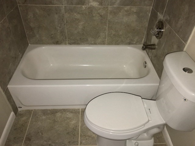 a bathroom with a toilet and a bath tub