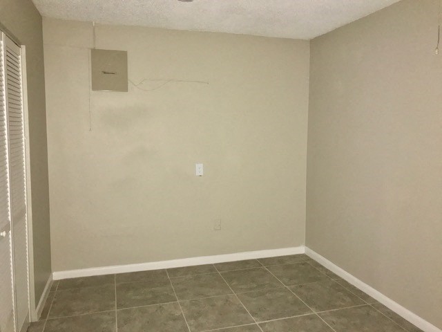 an empty room with tile floor and white walls