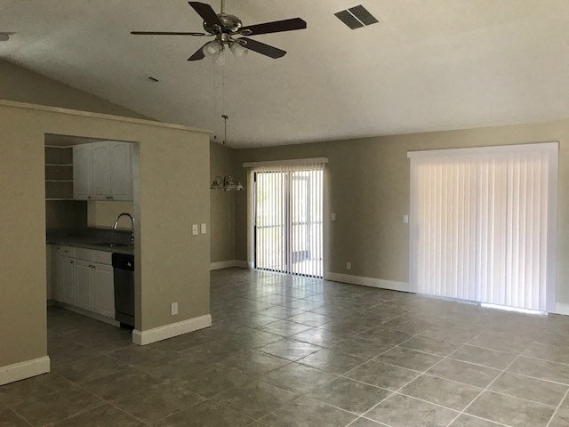 an empty kitchen and living room with a ceiling fan