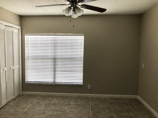 a living room with a window and a ceiling fan