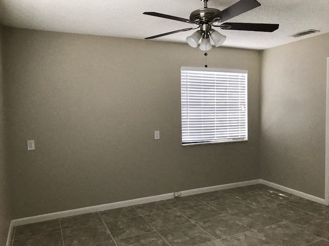 an empty room with a ceiling fan and a window