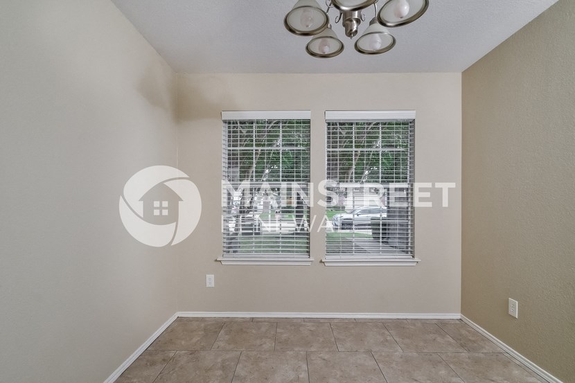 a living room with two windows and a tile floor