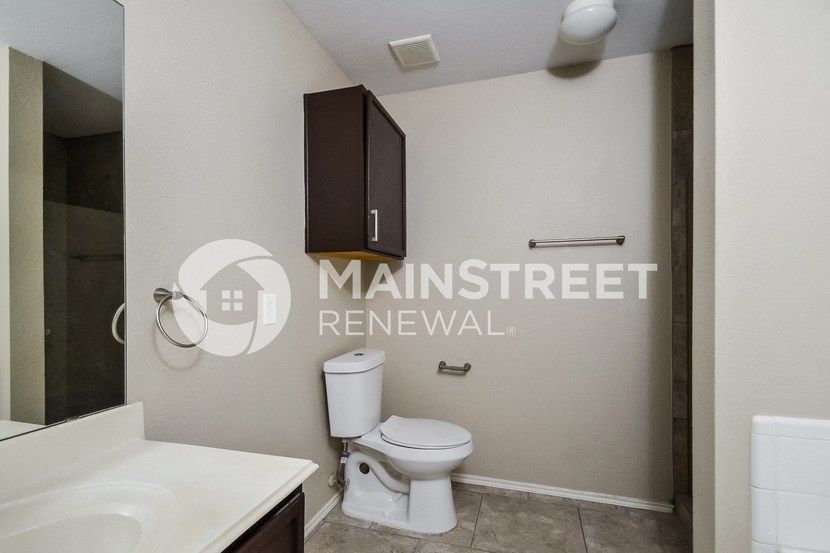 a bathroom with a toilet and a sink and a cabinet