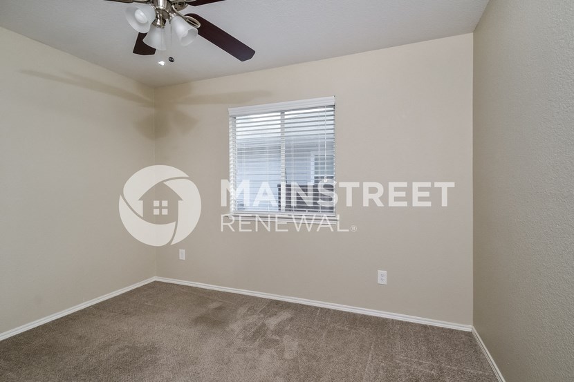 a bedroom with a ceiling fan and a window