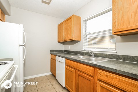 a kitchen with wooden cabinets and a sink and a refrigerator