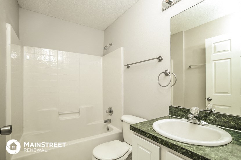 a white bathroom with a sink and a tub and a toilet