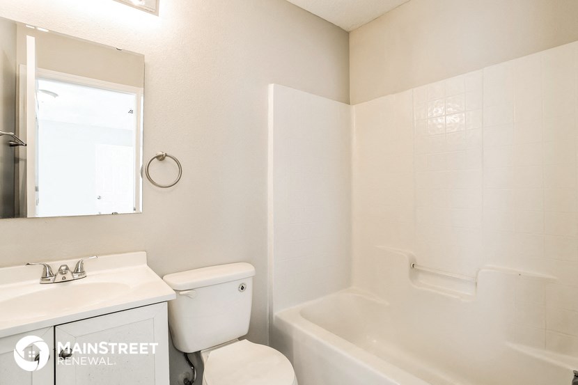 a bathroom with a toilet and a tub and a sink