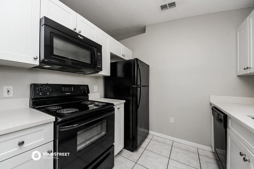 a kitchen with black appliances and a black refrigerator