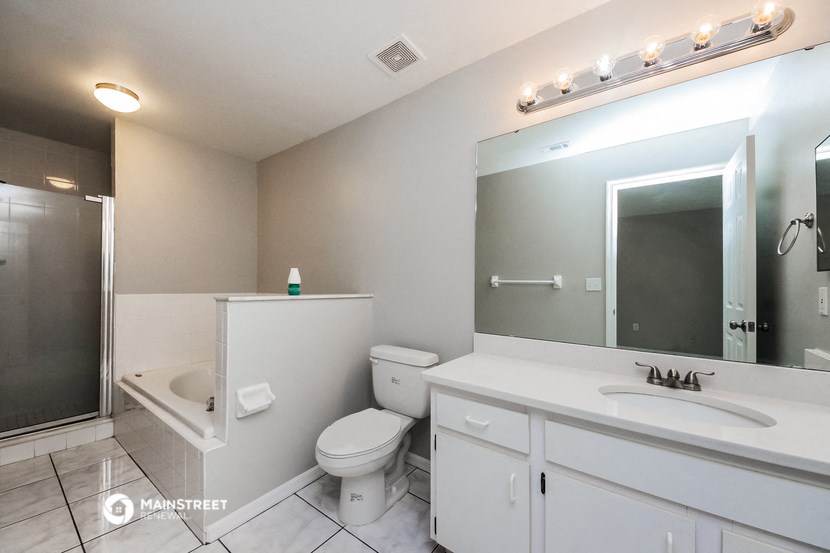 a bathroom with a large mirror and a toilet and a sink