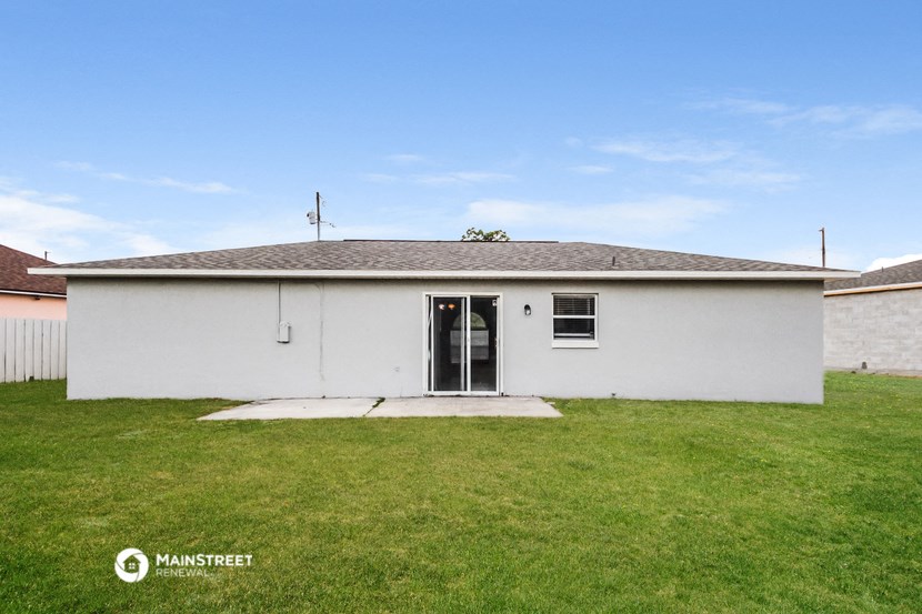 the front of a white house with a grass yard