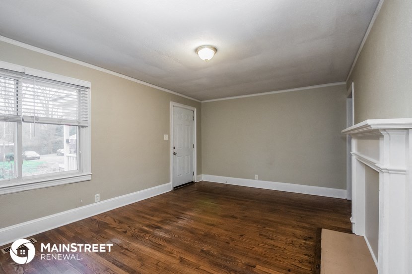 the living room of a house with wood floors and a white door