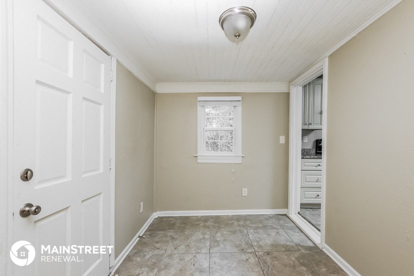 an empty room with a white door and a window