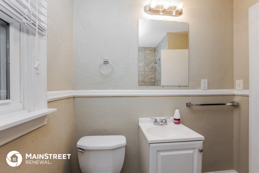 a bathroom with a toilet and a sink and a mirror