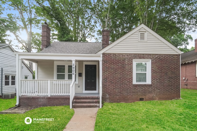 a small brick house with a porch and a white door