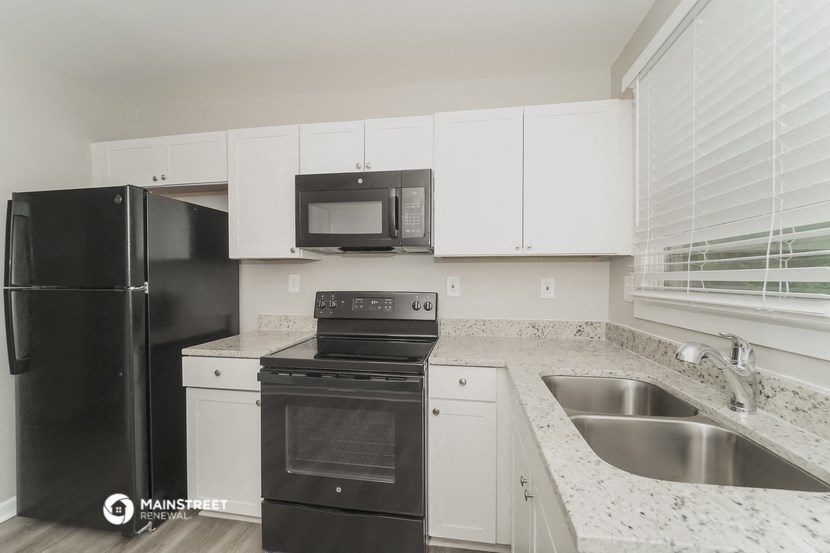 the preserve at ballantyne commons apartment kitchen with black appliances and white cabinets