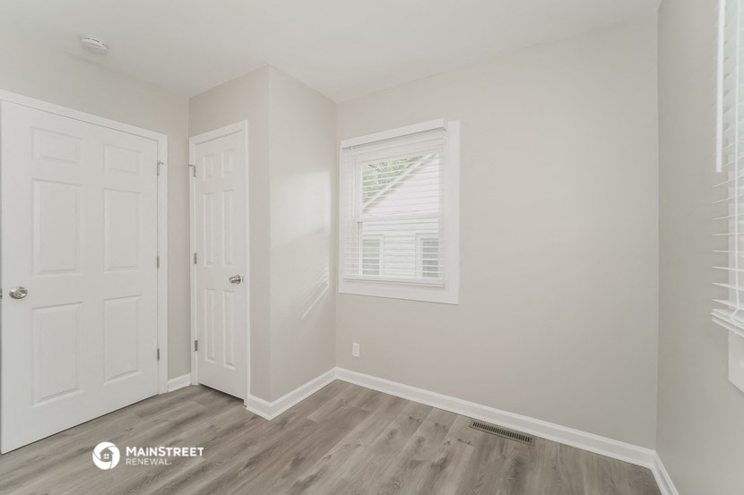 a bedroom with two closets and a door and a window