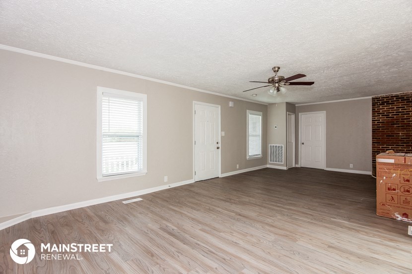a living room with a wood floor and a ceiling fan