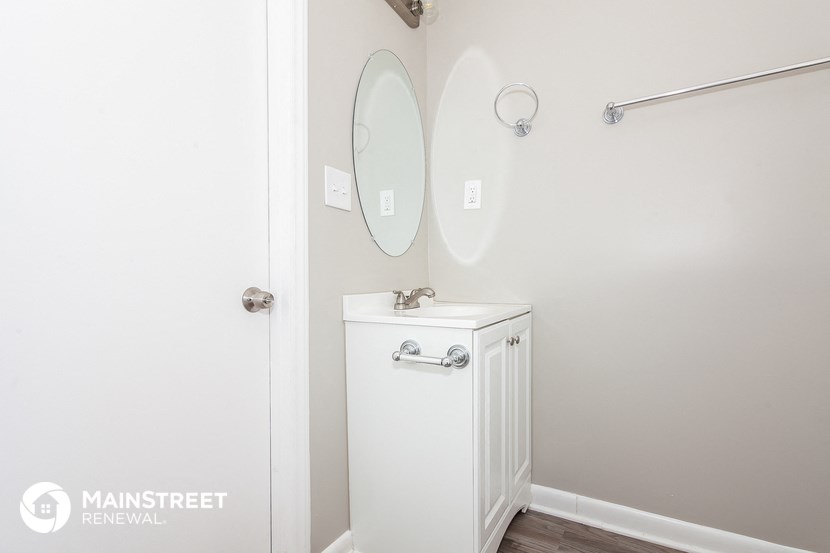 a small bathroom with a white vanity and a mirror