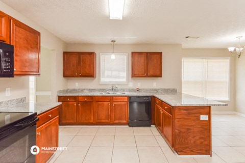 a kitchen with wooden cabinets and a counter top and a sink