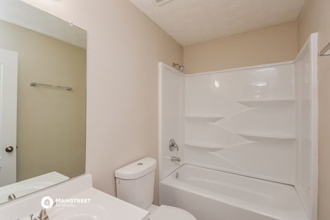 a bathroom with a tub and a toilet and a sink