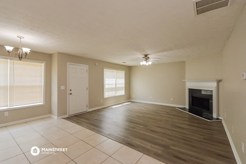 the spacious living room with fireplace and tiled flooring