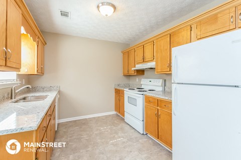 a kitchen with white appliances and wooden cabinets