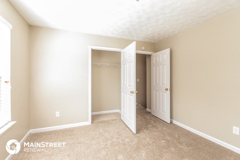 a master bedroom with a closet and a door to the bathroom