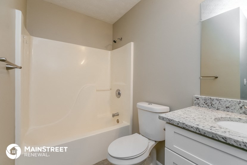 a bathroom with a tub and a sink and a toilet