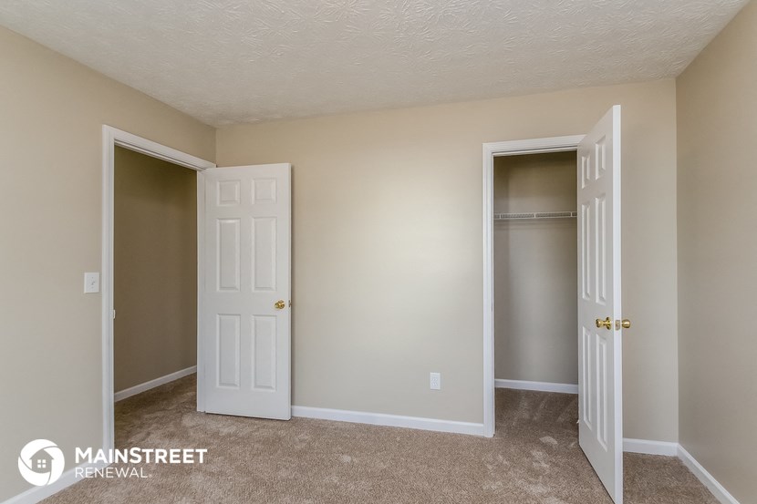 a bedroom with two closets and two doors