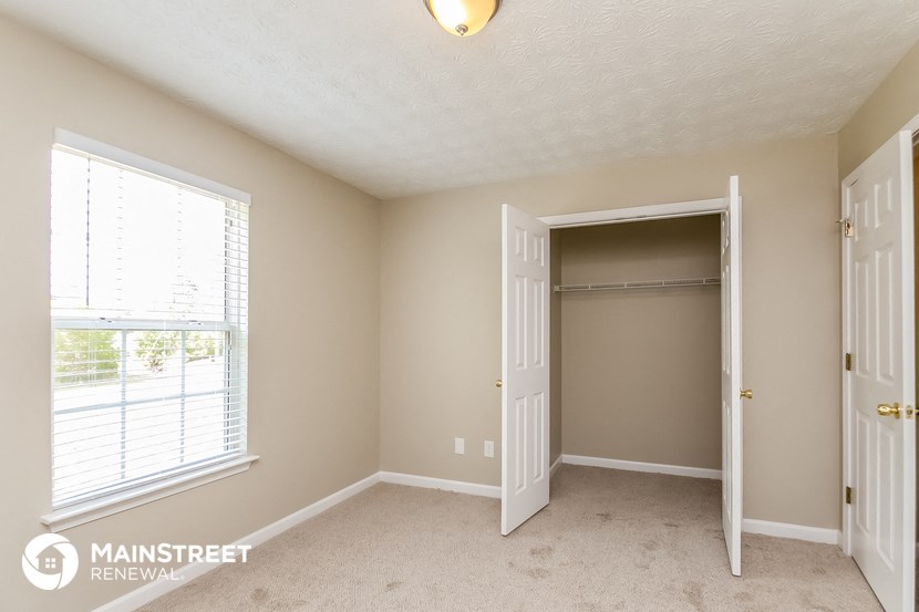 a bedroom with a closet and an open door and a window