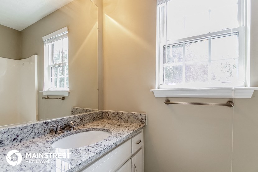 a bathroom with a sink and a mirror and a window