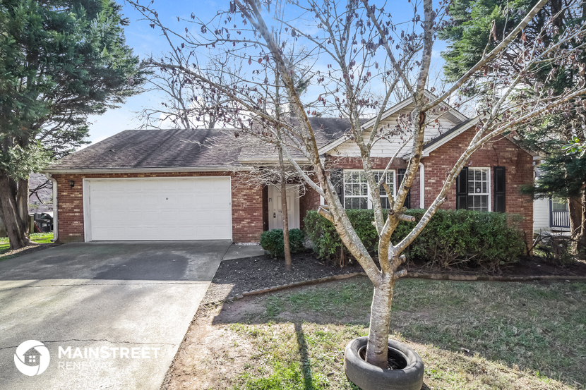 a small brick house with a white garage door