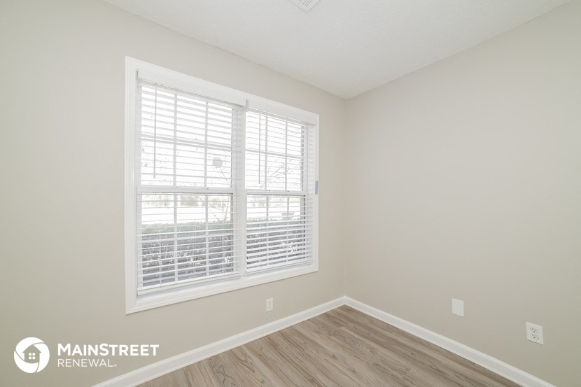 the living room of a new home with a large window and wooden floors
