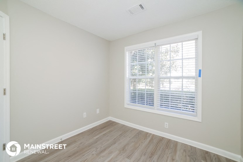 the living room of a new home with wood flooring and a large window