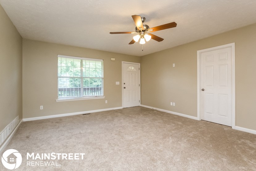 the master bedroom has a carpeted floor and a ceiling fan