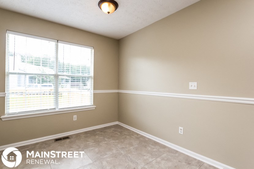the living room of an empty home with a large window
