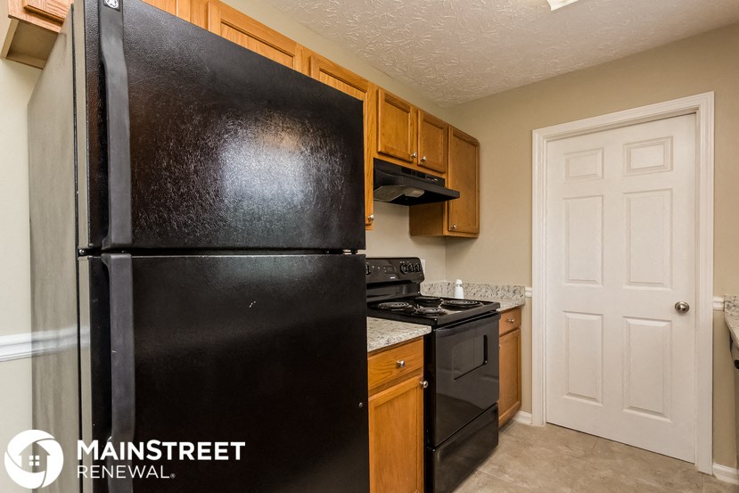 a kitchen with a refrigerator and a stove and a door