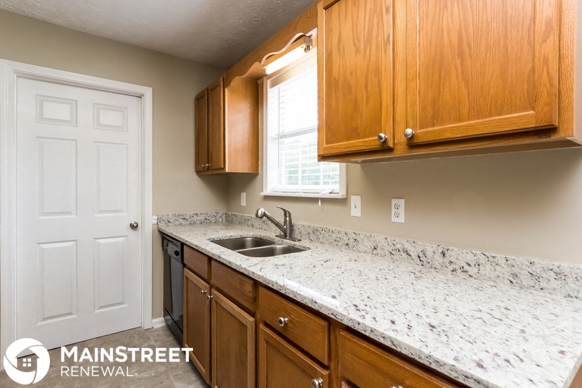 a kitchen with marble countertops and wooden cabinets and a sink
