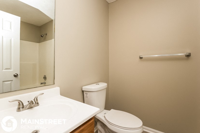 a bathroom with a toilet and a sink and a mirror