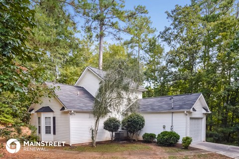 a white house with a yard and trees