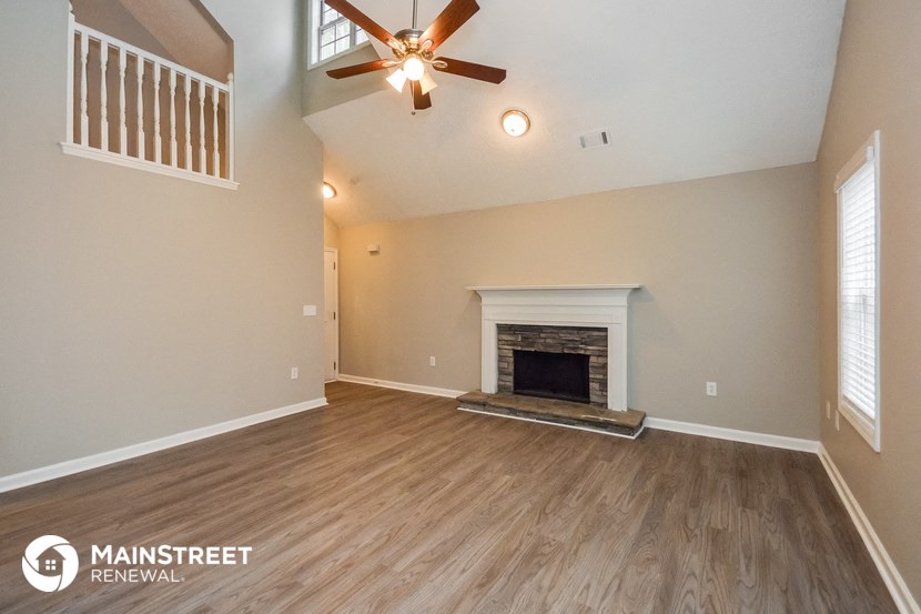 the living room with fireplace and ceiling fan