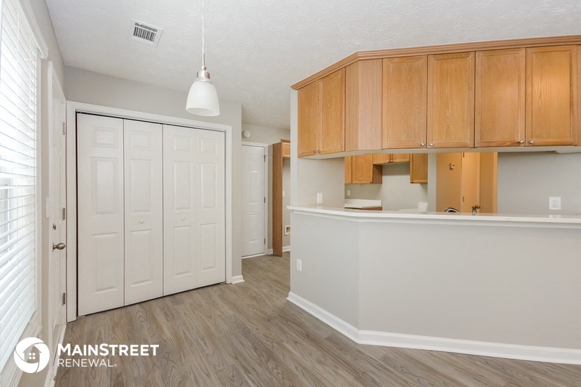 the kitchen and living room of an apartment with wood flooring